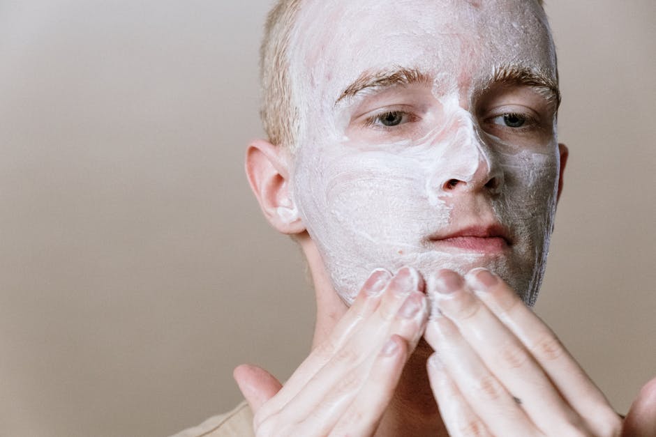 Close-up of a man applying facial cleanser for a refreshing skincare routine, focusing on self-care and health
