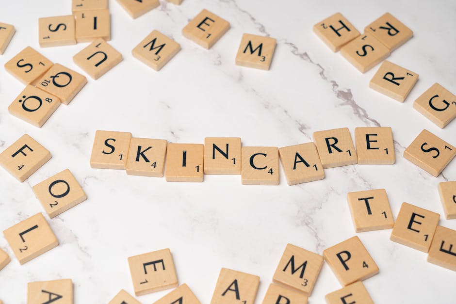 Wooden letter tiles spelling 'skincare' on a marble surface, symbolizing beauty