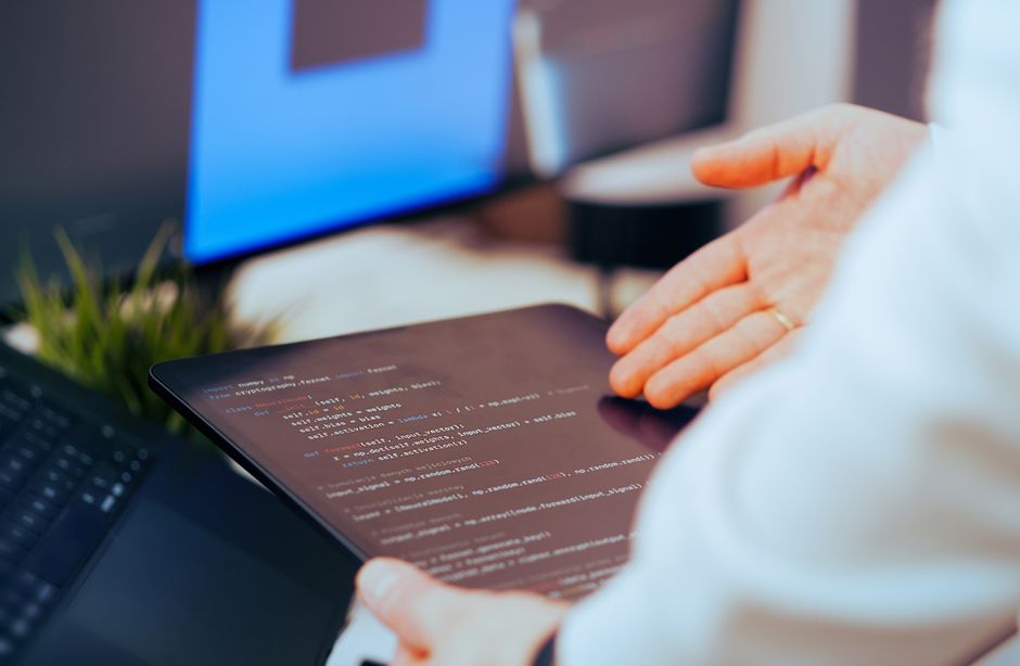 Software developer analyzing code on a tablet u modernom uredu.